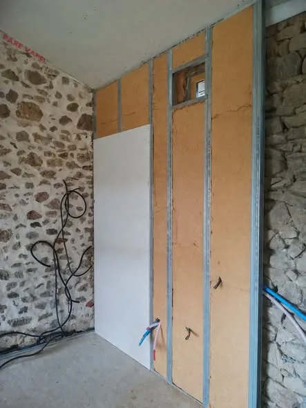 Doublage de mur en cours avec plaque et ossature