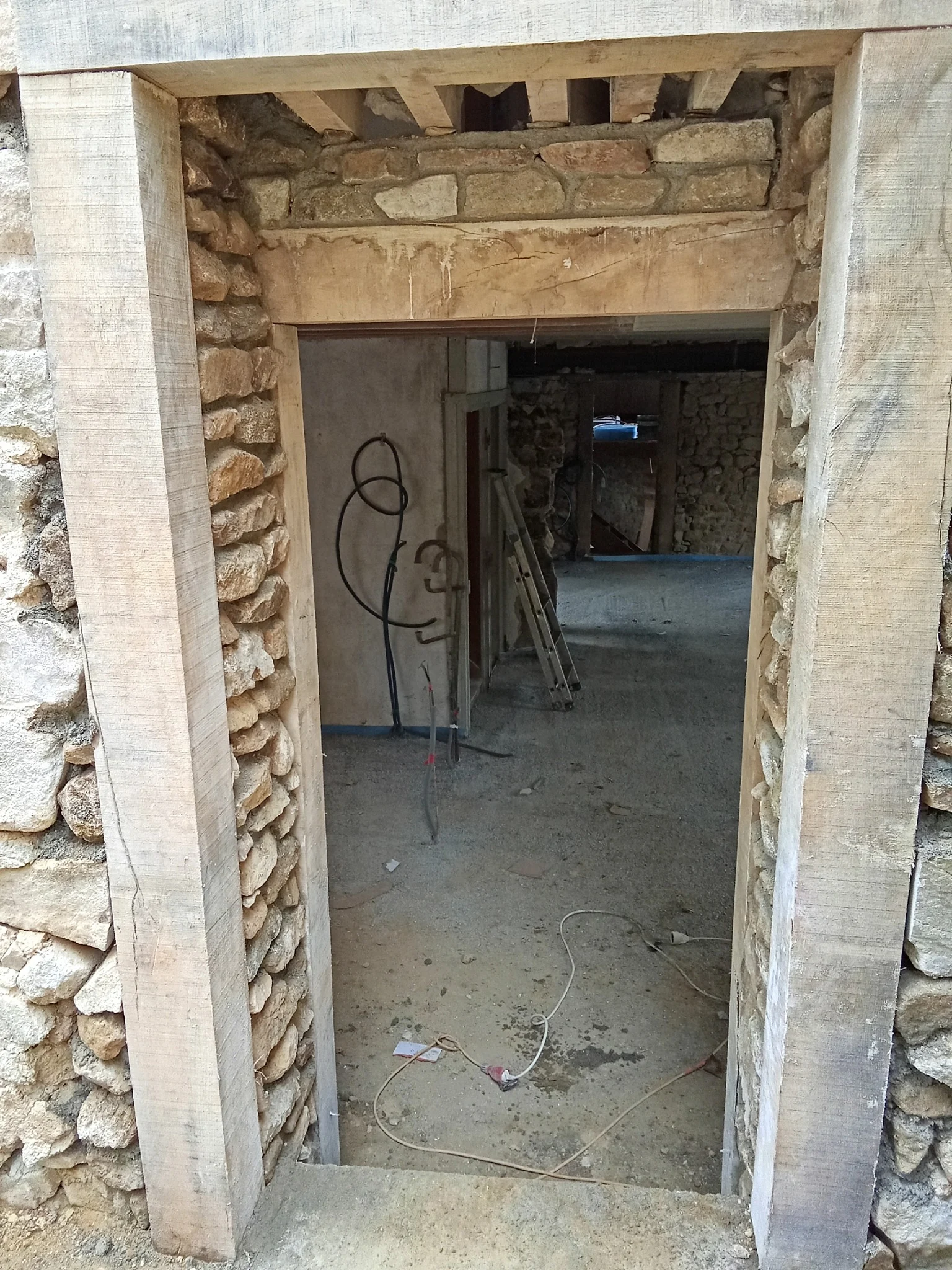 Ouverture de porte avec encadrement bois dans une maçonnerie en pierre