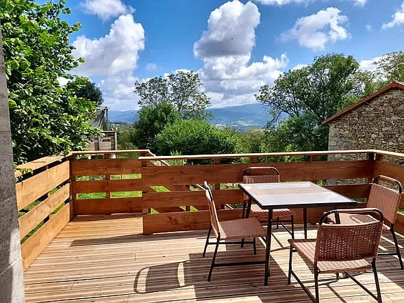 Terrasse extérieure en bois avec vue dégagée sur la campagne